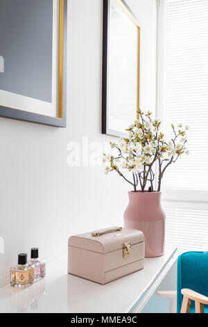 Interior design of white woman's room with pink pastel decoration, vase, flowers, blue armchair and painting Stock Photo