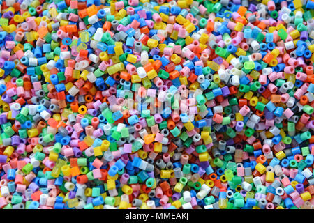 A variety of different coloured hama beads used by children to make craft objects Stock Photo