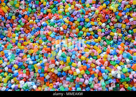 A variety of different coloured hama beads used by children to make craft objects Stock Photo