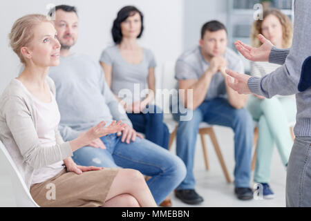 Woman psychologist speaking during group psychotherapy session Stock Photo