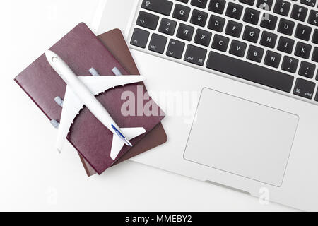 passport , white plane model and computer laptop on white background . travel , visa and vacation concept Stock Photo