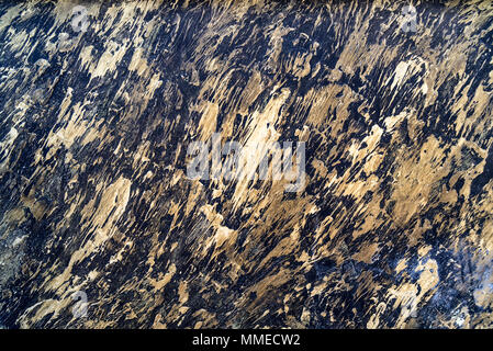 Close up dark metal surface with bronze smears on it for abstract grunge background Stock Photo