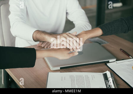 Three business partners team with hands together to greeting start up project in office. Business meeting concept Stock Photo