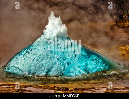Geyser in Iceland begins eruption by first forming a bubble of hot water, before bursting into the air Stock Photo