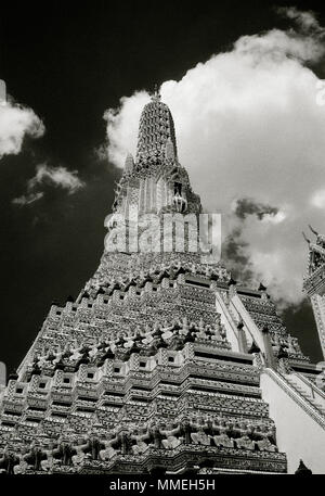 Dramatic chiaroscuro sky and the Buddhist Temple of Dawn - Wat Arun Temple in Thonburi Bangkok Yai in Thailand in Southeast Asia Far East. Travel B&W Stock Photo