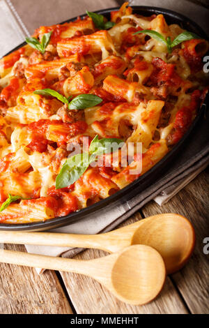 Pasta ziti with bolognese sauce and cheese close-up on the table. vertical, rustic style Stock Photo
