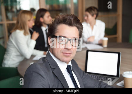 Middle-aged businessman investor wearing glasses looking at came Stock Photo