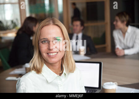 Smiling middle-aged businesswoman executive looking at camera at Stock Photo
