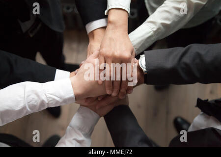 Motivated business people put hands together, trust and support  Stock Photo