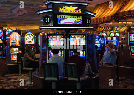 Gamblers playing Megabucks slot machines, Bellagio Casino, Las Vegas, Nevada. Stock Photo