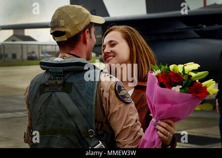 A 492nd Fighter Squadron member greets his wife after returning from a deployment, Oct. 9, at Royal Air Force Lakenheath, England. F-15E Strike Eagles and Airmen from the 492nd FS and supporting units across the 48th Fighter Wing returned from a six-month deployment to an undisclosed location in Southwest Asia. (U.S. Air Force photo/ Tech. Sgt. Matthew Plew) Stock Photo