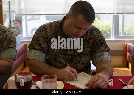 CAMP HANSEN, OKINAWA, Japan— Sgt. Maj. Michael West fills out a score sheet during a Food Service Specialist of the Quarter Competition Oct. 31 aboard Camp Hansen, Okinawa, Japan. West, along with other judges asked competitors about their inspirations and what they wanted to do in the Marine Corps. The competitors were judged on: serving methods and presentation, portion size, nutritional balance, menu and ingredient compatibility, creativity and flavor, texture and doneness. West is the sergeant major of Camp Hansen. Stock Photo