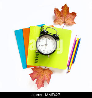 Colorful school supplies, notebooks and alarm clock on white. Top view, flat lay. Square image. Stock Photo
