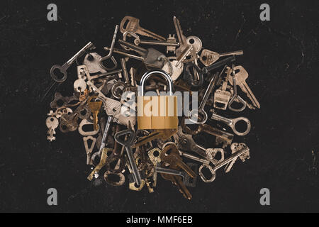 top view of heap different metal keys with lock isolated on black Stock Photo
