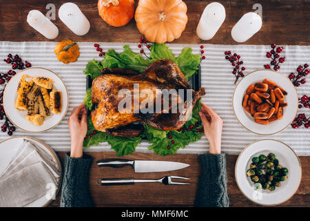 Man serving baked turkey on table Stock Photo