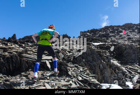 Man running on a rural road during sunset in the mountains. Stock Photo