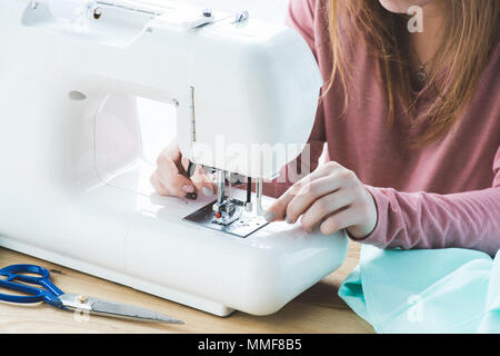 cropped image of young seamstress using sewing machine at workplace Stock Photo