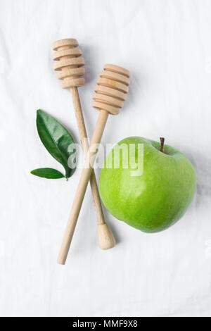 Wooden Honey Dippers Ripe Green Apple Leaves on White Cotton Linen Fabric Background. Organic Cosmetics Ayurveda Healthy Lifestyle Skin Care Concept.  Stock Photo