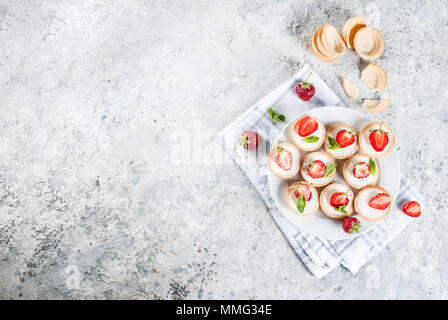 Summer sweet homemade dessert, Mini cheesecakes with strawberry on grey stone table copy space top view Stock Photo