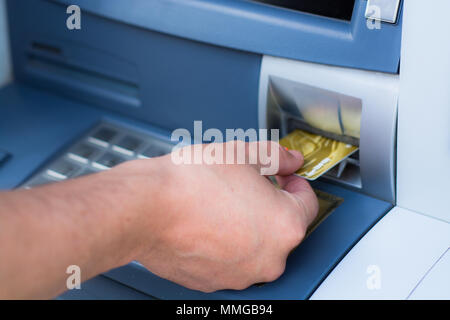 Hand inserting ATM credit card Stock Photo