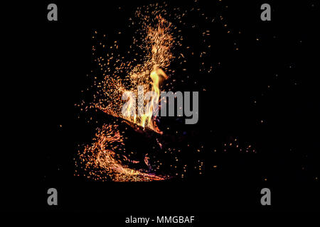 Fire with sparks and flames. Dramatic flare of orange fire with black background. Stock Photo