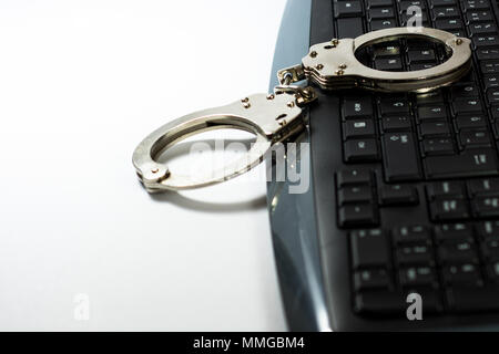 Handcuffs on keyboard Stock Photo