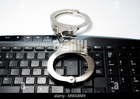 Handcuffs on keyboard Stock Photo