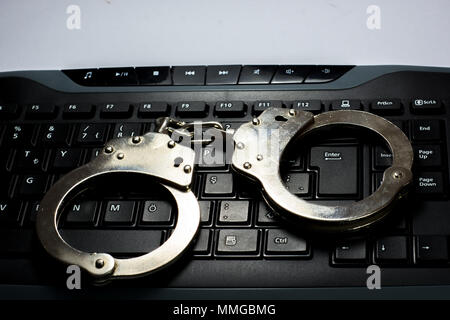 Handcuffs on keyboard Stock Photo
