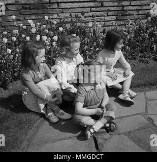 1950s GROUP OF 5 CHILDREN SITTING ON NEWSSTAND READING MAGAZINES Stock ...