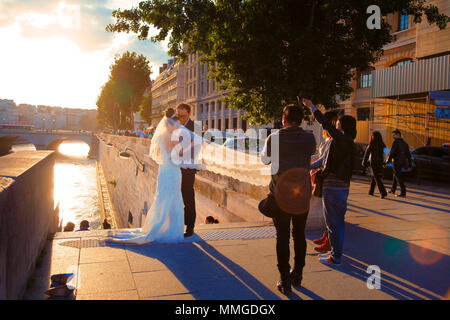 PARIS, FRANCE - JUNE 14, 2013 - Couple of newlyweds are photographed on the Seine river embankment in Paris Stock Photo