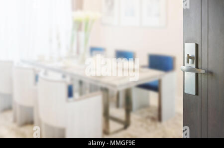 opened wooden door to dining room in modern home with elegant table setting Stock Photo