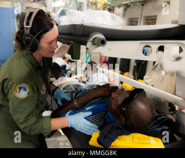 U.S. Air Force Master Sgt. Mary-Beth Young, assigned to the 45th Aeromedical Evacuation Squadron, tends to patients aboard a C-17 Globemaster III while enroute from St. Croix to Dobbins Air Reserve Base, Ga., Sept. 24, 2017. Reserve Citizen Airmen conduct humanitarian mission to St. Croix to evacuate victims affected by Hurricane Maria. (U.S. Air Force photo by Tech. Sgt. Peter Dean) Stock Photo