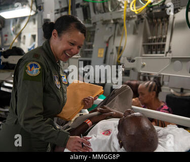 U.S. Air Force Maj. Gavril Goodman assigned to the 45th Aeromedical Evacuation Squadron, comforts a patient aboard a C-17 Globemaster III while enroute from St. Croix to Dobbins Air Reserve Base, Ga., Sept. 24, 2017. Reserve Citizen Airmen conducted humanitarian missions to St. Croix to evacuate victims affected by Hurricane Maria. (U.S. Air Force photo by Tech. Sgt. Peter Dean) Stock Photo