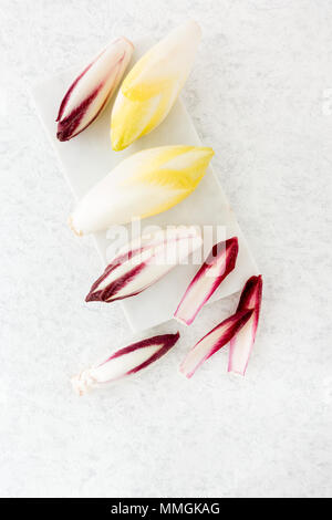 Top view of red chicory and chicory on a marble chopping board. Stock Photo