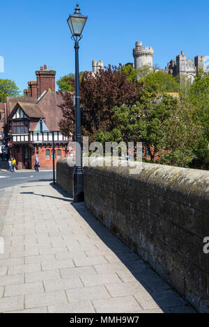 ARUNDEL, UK - MAY 5TH 2018: The view while walking across Arundel Bridge with the Post Office ahead and the sight of Arundel Castle looming over the t Stock Photo