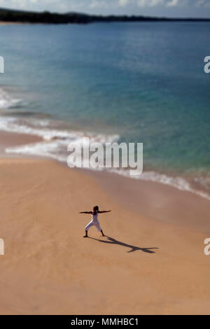 Selective focus on woman practicing yoga at Makena, Maui, Hawaii. Stock Photo
