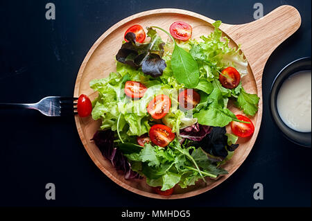 Fresh mixed vegetables salad on a wooden plate Stock Photo