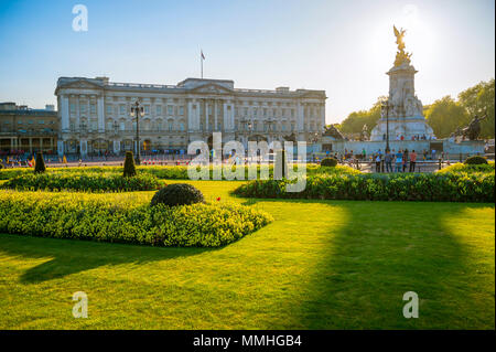 LONDON - MAY 7, 2018: View across flower beds in front of Buckingham Palace at sunset.