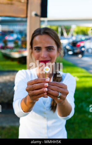 Beautiful woman holding a daisy in her hands Stock Photo