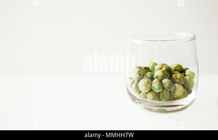 green roasted wasabi bean nuts dessert snack in a glass on white background. Stock Photo