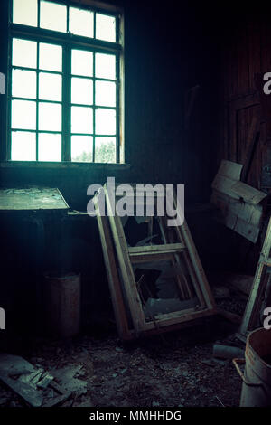 window light  into a dilapidated shed, containing rusty items and broken windows Stock Photo