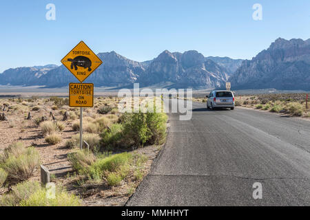 Vehicle passing a tortoise crossing sign along road in the Red Rock Canyon National Conservation Area outside of Las Vegas, Nevada Stock Photo