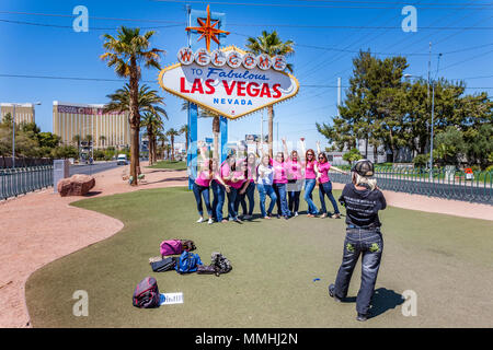A visiting wedding party poses under the landmark Welcome to Fabulous Downtown Las Vegas sign in Las Vegas, Nevada Stock Photo