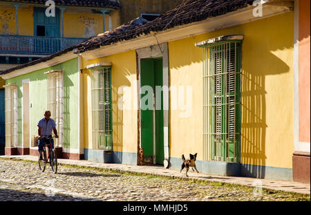 Trinidad, Cuba; man cycling with his dog in the old town Stock Photo