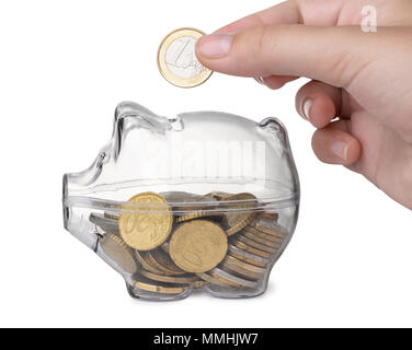 Close up of hand putting coin into piggy bank isolated on white Stock Photo