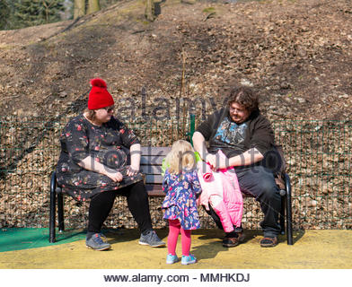 https://l450v.alamy.com/450v/mmhkdj/obese-man-and-woman-sitting-on-a-park-bench-blond-toddler-girl-is-standing-close-to-them-at-the-cytadela-park-in-poznan-poland-mmhkdj.jpg