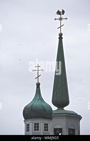 Sitka, Alaska, USA: Two bald eagles (Haliaeetus leucocephalus) perched on the top of the spire of St. Michael’s Cathedral. Stock Photo