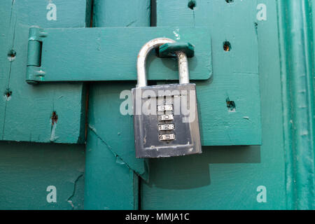 Close up of an old wooden door with numbers combination padlock Stock Photo