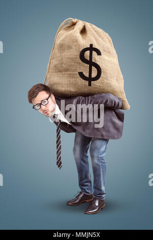 Businessman carrying an oversized moneybag Stock Photo