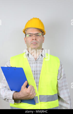 Middle Age Worker in Safety Gear Holding Checking Clip Board Stock Photo